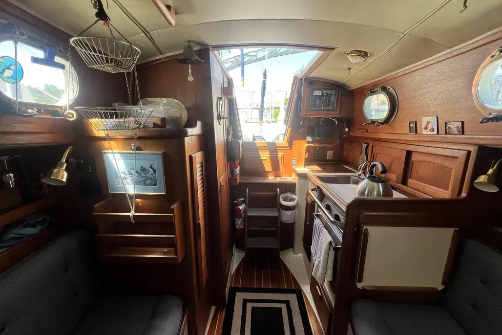 The Dana 24's galley maximizes function within tight confines, featuring a removable 20-in. x 25-in. counter atop the two-burner gimbaled stove and a 10-in. x 14-in. stainless steel sink with additional counter space over the ice box. Courtesy of YachtWorld.com