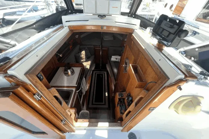 Dana24-Interior Entrance Despite her compact size, the Dana 24 offers genuine 6-ft. headroom in the saloon and sleeping space for two 6-ft. 2-in. adults in the V-berth. Hand-rubbed oiled teak surfaces, bronze ports, and the absence of a forward bulkhead creates surprising spaciousness. Courtesy of Yachtworld.com