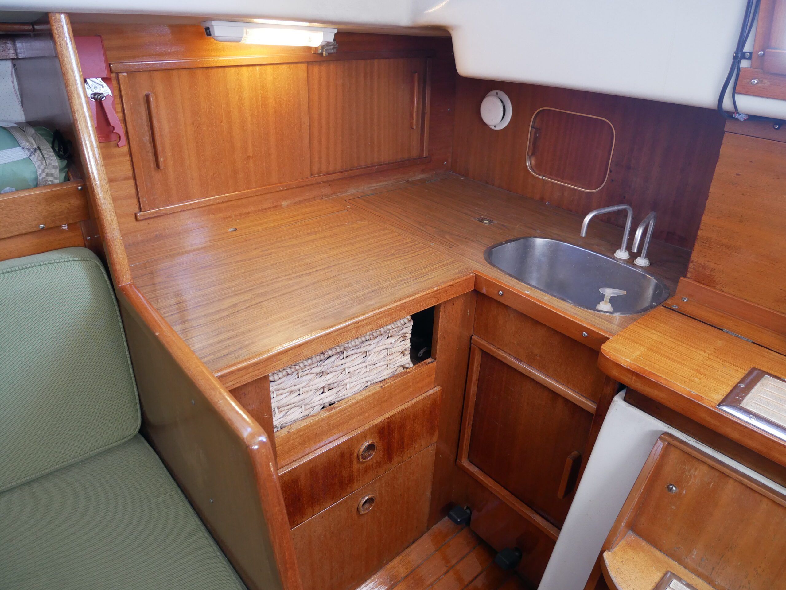 Most Ballad galleys offer just an icebox, to the left of the sink, and a two-burner stove (under the removable counter). The small sliding hatch behind the sink lets you drop garbage in a can that lives in the starboard cockpit locker, a novel design touch. (Photo/ Doug Henschen)