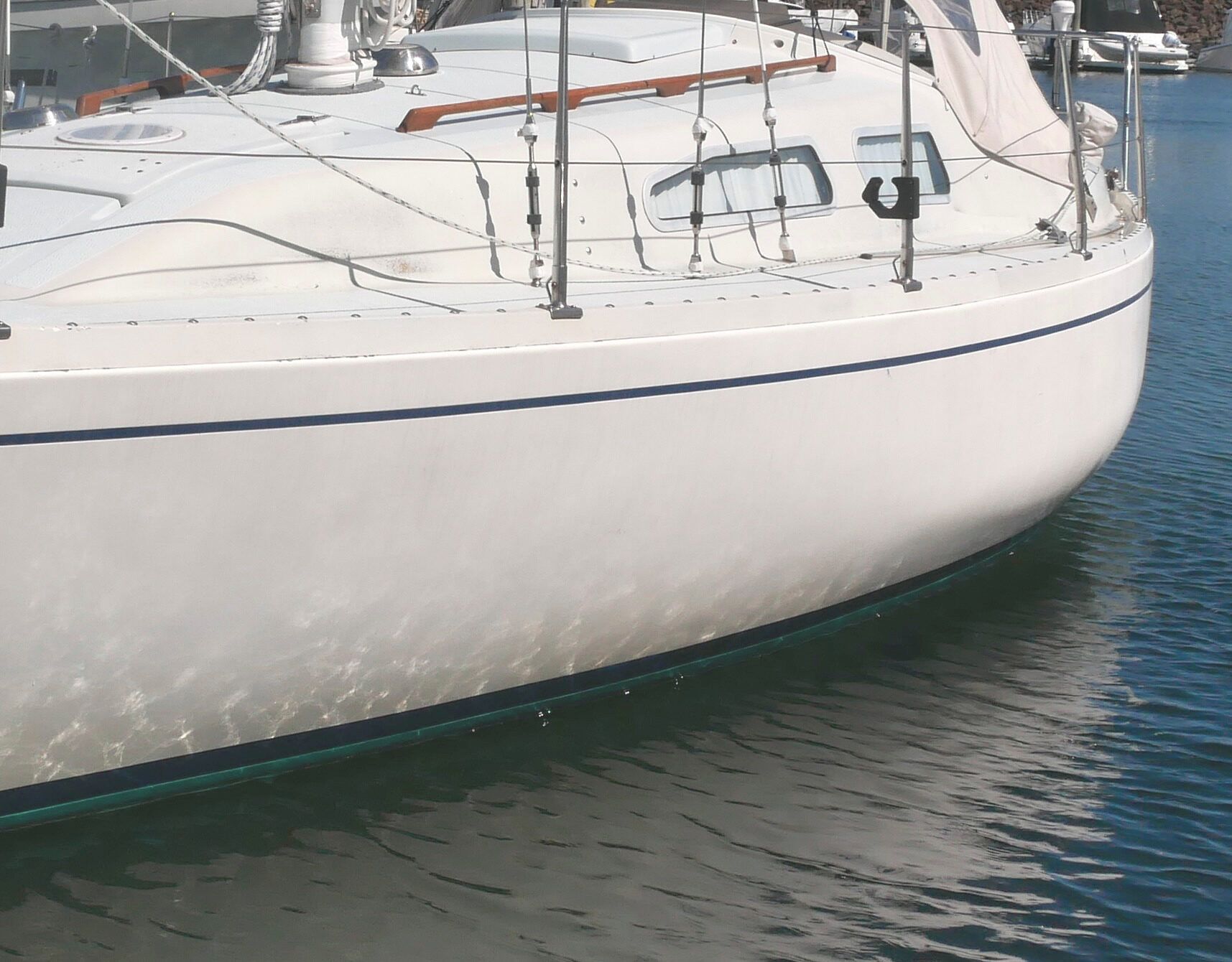 The Ballad’s knuckle-shaped hull profile amidships moves the center of buoyancy outboard and helps the boat stand up to the wind. Visible atop the 2-in. high toe rail are the rounded heads of stainless bolts that hold the hull-deck joint together. Port and starboard sail tracks curve inward, toward the stays, as you move the sheet lead cars forward. (Photo: Doug Henschen)
