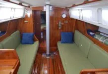 The Ballad salon offers plenty of light. Some models, like the one pictured, have upgraded teak and holly soles. Ventilation is limited to two passive overhead vents. Marius Draeger has upgraded his boat with opening rear windows, available from an aftermarket supplier in Denmark, the capital of Ballad ownership. (Photo/ Doug Henschen)