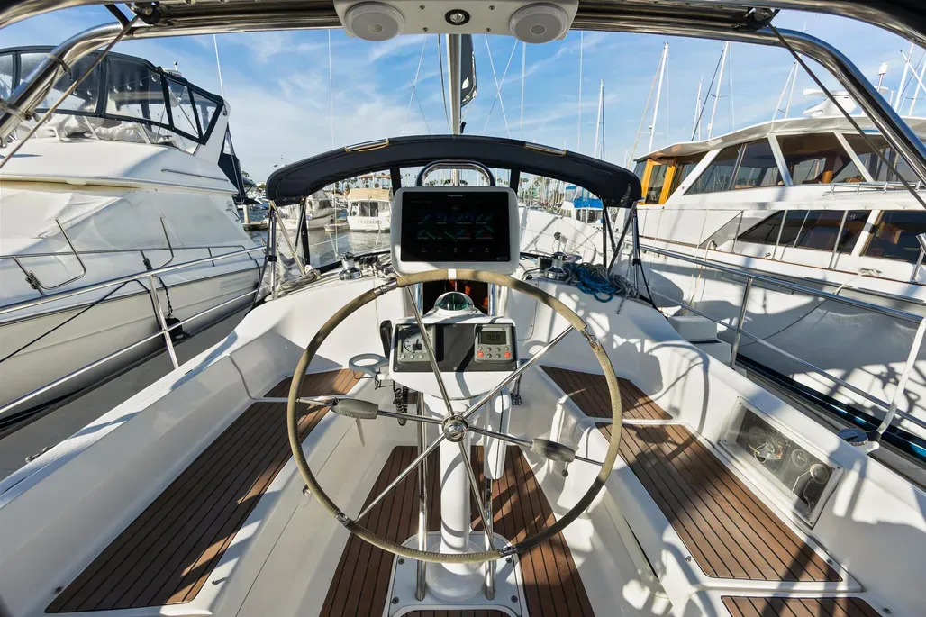 The Hunter 38's spacious cockpit seats eight comfortably with 6-ft. long seats, pod seating on the stern rails, and a folding destroyer-style wheel. The bimini frame over the cockpit supports the traveler and mainsail controls. Courtesy of YachtWorld.com