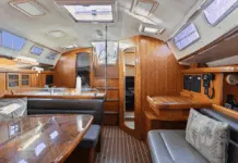 The main saloon offers 6-ft. 6-in. headroom with teak cabinetry, solid wood handrails, and settees that seat six around a 36-in. x 42-in. dining table. The low-maintenance Everwear laminate sole replaced traditional teak and holly. Courtesy of YachtWorld.com