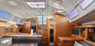 The main saloon offers 6-ft. 6-in. headroom with teak cabinetry, solid wood handrails, and settees that seat six around a 36-in. x 42-in. dining table. The low-maintenance Everwear laminate sole replaced traditional teak and holly. Courtesy of YachtWorld.com