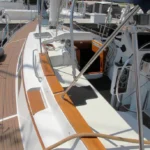 The freestanding 62-ft. carbon fiber mast eliminates the rigging maintenance typical of stayed rigs, with the thicker aerodynamic profile engineered to flex under load like an aircraft wing—spilling wind in gusts and providing stability without shrouds or stays. Photo courtesy of YachtWorld.com