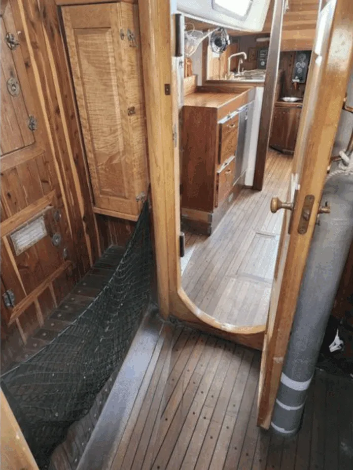 Screenshot 2025-11-17 at 10.14.24 AM The companionway and main cabin entrance showcases classic teak joinery throughout, with abundant storage lockers, a spacious galley to starboard, and traditional teak-and-holly sole. The deep companionway sill provides a secure threshold for offshore passages. Courtesy of SailboatListings.com