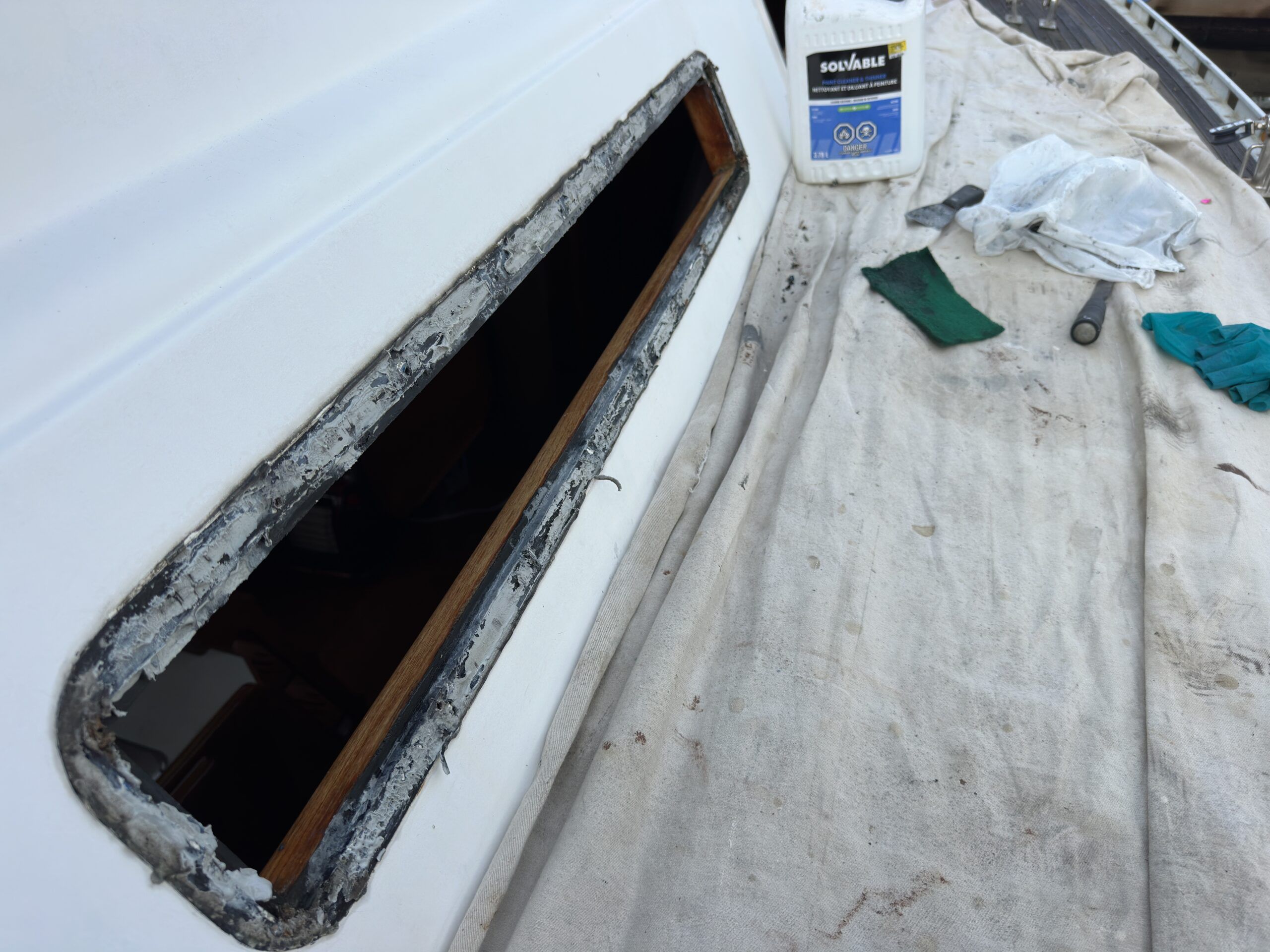 Old windows removed from the cabin of a Hylass 44. This installation has a SS metal frame around the outside. The plexiglass is set into the cabin trunk as a frameless installation. Note the protective drop sheet to protect the teak deck. (Photo/ Bert Vermeer)