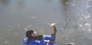 Reading Isaac Asimov. To demonstrate humorously, but also accurately, that I spent considerable time in ice water for the test. It was as comfortable like a water bed and reading helped pass the time. In between I performed climbing, jumping, and boarding tests, as required by the immersion suit standard. I swam around the harbor a little bit, because I could and because with some ice on the water, there was zero traffic. (Photo/ Drew Frye)