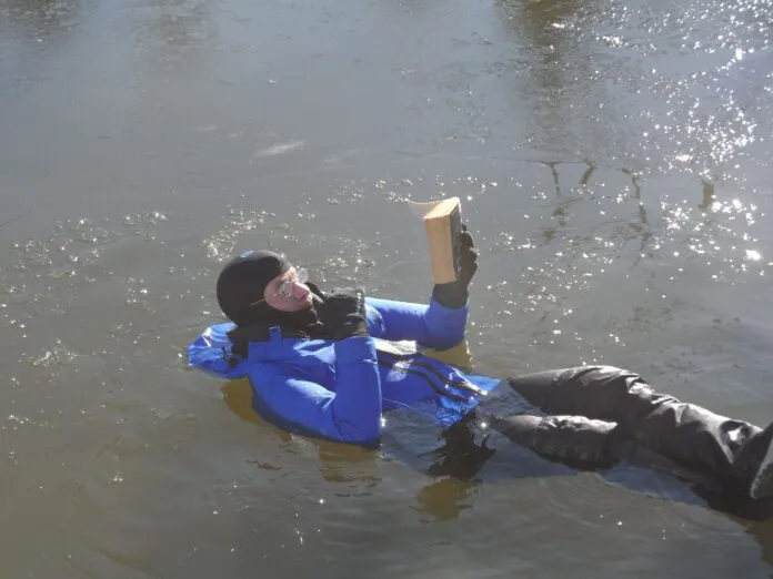 1 Reading Isaac Assimov Reading Isaac Asimov. To demonstrate humorously, but also accurately, that I spent considerable time in ice water for the test. It was as comfortable like a water bed and reading helped pass the time. In between I performed climbing, jumping, and boarding tests, as required by the immersion suit standard. I swam around the harbor a little bit, because I could and because with some ice on the water, there was zero traffic. (Photo/ Drew Frye)