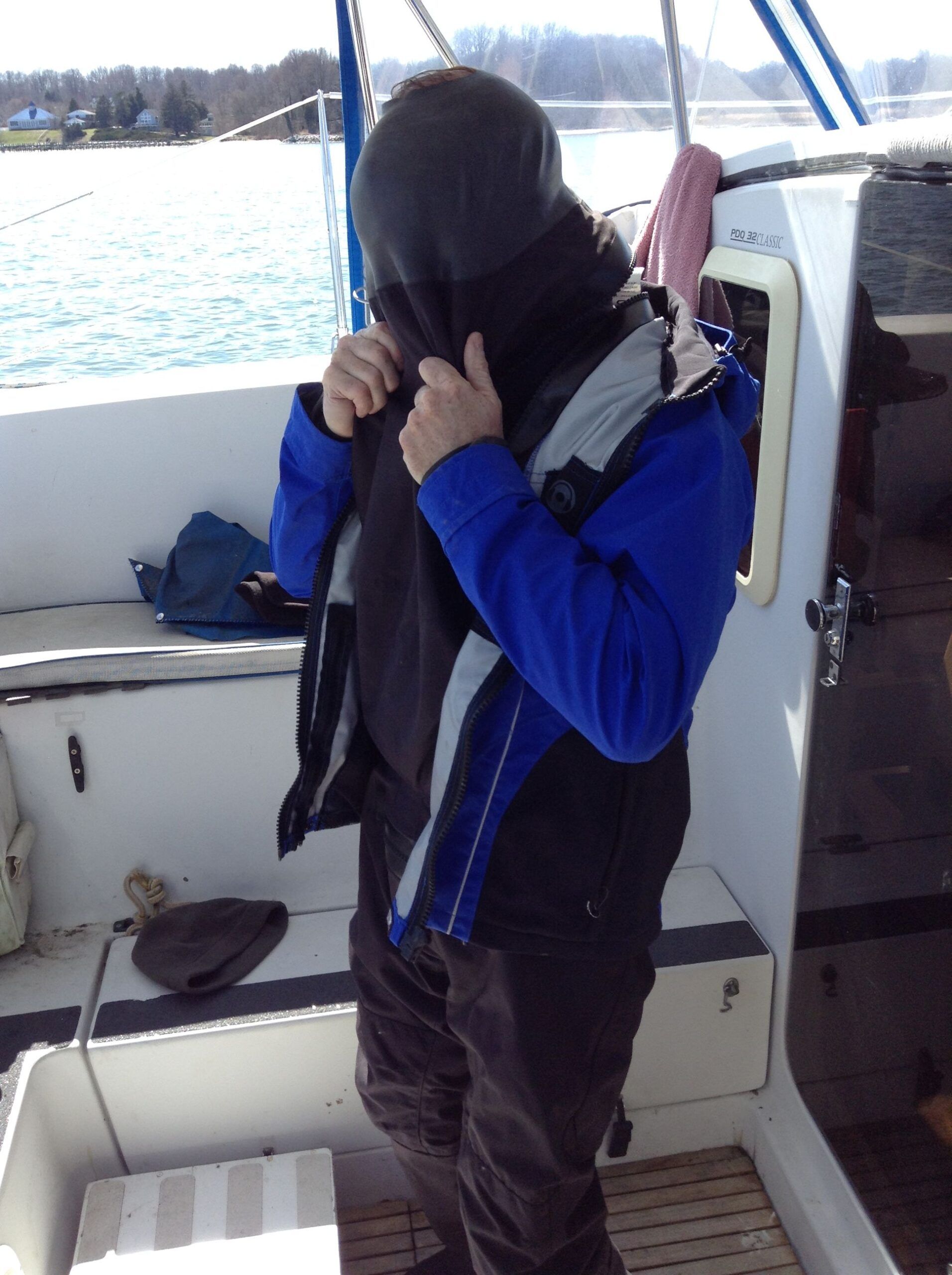 The author fitting his head through the dry suit. (Photo/ Drew Frye)