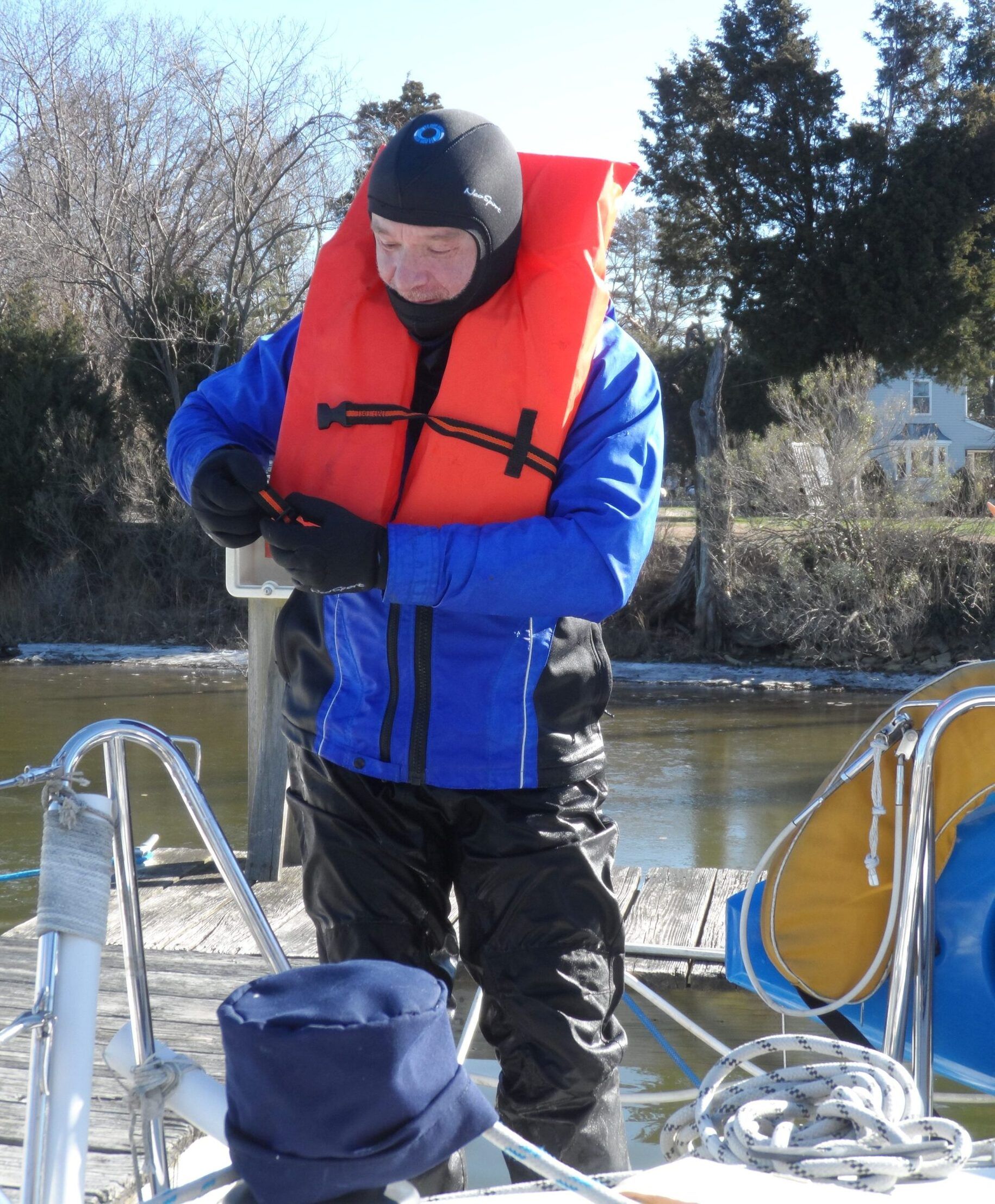 A PFD is required for a dry suit to be reliably self righting. If the air shifts to the feet you will float upside down, although righting from that position is easy and the air flows back up to the shoulders. The more air you squeeze out of the suit while donning, the less the effect. The best procedure is to go down a ladder and close the zipper when shoulder-deep. Alternatively, squat on deck and squeeze out as much air as much as you can before closing the zipper. (Photo/ Drew Frye)