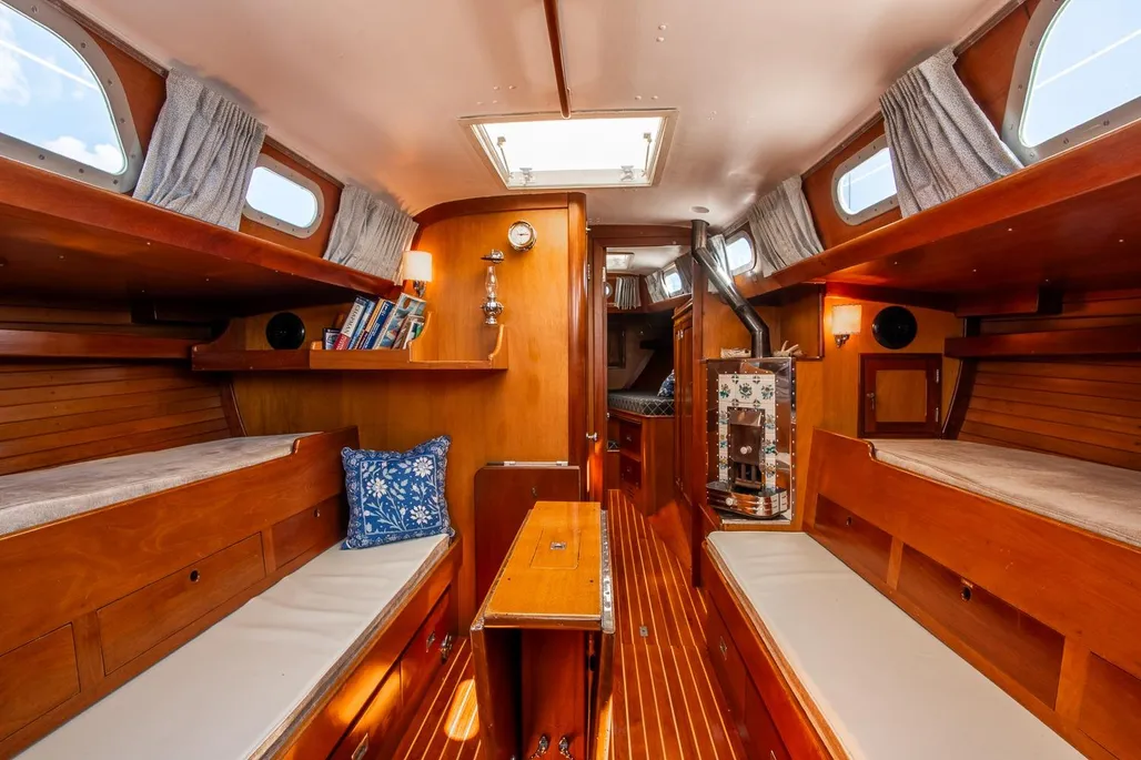 Cedar-lined lockers and varnished joinery reflect Hinckley's philosophy of building a wooden boat inside the fiberglass hull, with buyers selecting cherry, white ash, or mahogany trim. Courtesy of YachtWorld.com