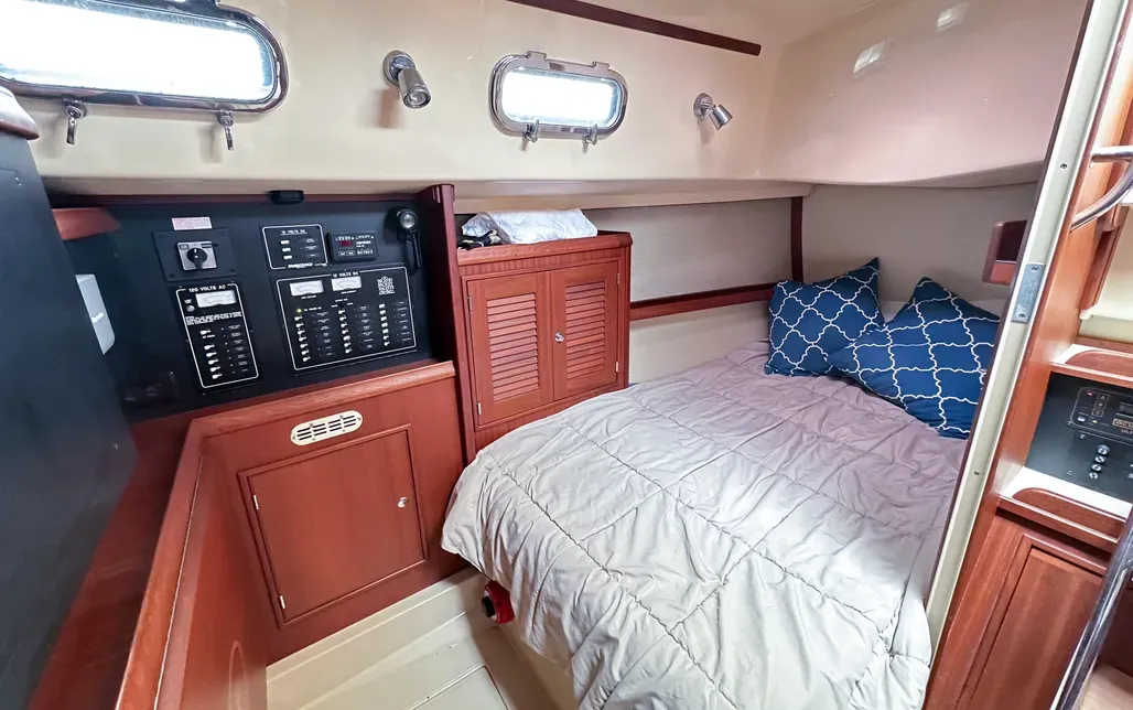 The aft port stateroom offers 6-ft., 4-in. standing headroom, a hanging locker, bureau and full-length mirror. Our test boat was fitted with a single inner-spring mattress; a two-piece mattress would simplify access to under-berth storage. (Photo/ McCann Yachts)