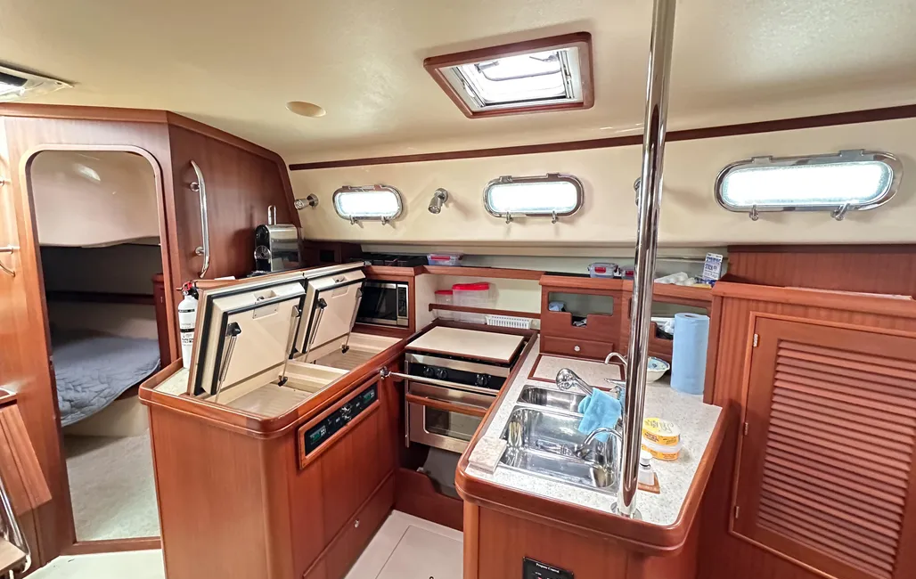 The U-shaped galley sits just aft of the mast to port, near the boat's fore-and-aft center. An overhead hatch and opening portlights provide ventilation and a view—a significant advantage over the aft-corner galleys found on most boats this size. (Photo/ McCann Yachts)