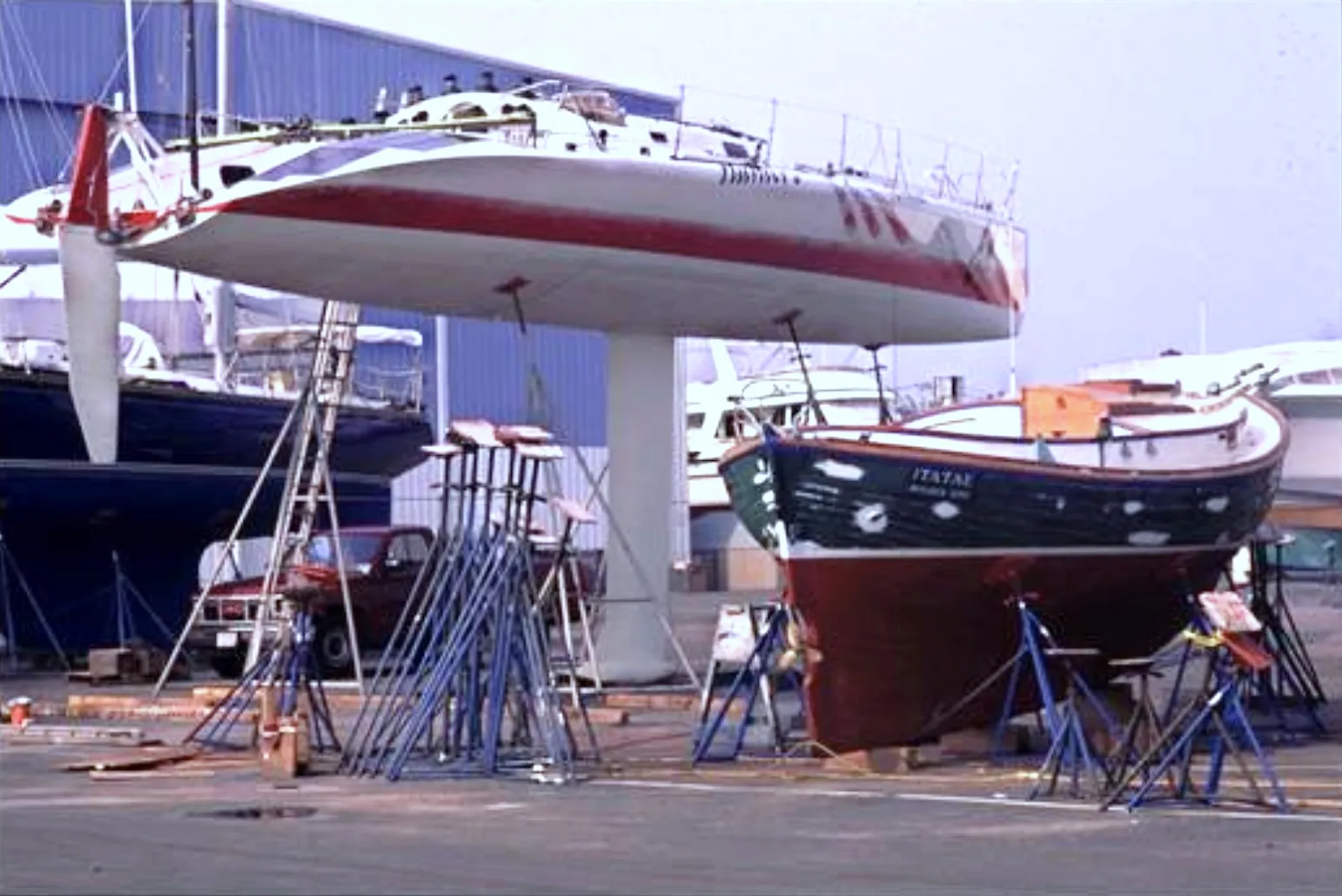 A side-by-side comparison illustrates two distinct approaches to stability. The modern racer (left) utilizes a wide beam for initial stability and a deep, high-aspect fin keel with a bulb to lower the center of gravity (CG). Beside it, the traditional double-ender relies on a full keel and heavier displacement. While the racer's deep draft maximizes the righting arm, the text notes that such appendages can limit cruising grounds compared to the moderate draft of the traditional vessel. (Photo/ Ralph Naranjo)