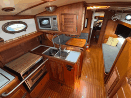 The Union 36's U-shaped galley to port features a deep double sink, three-burner stove/oven, and meticulous teak joinery throughout. (Photo courtesy of YachtWorld.com)