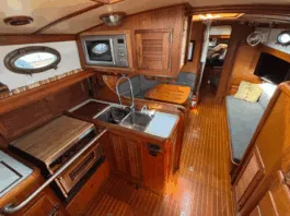 The Union 36's U-shaped galley to port features a deep double sink, three-burner stove/oven, and meticulous teak joinery throughout. (Photo courtesy of YachtWorld.com)