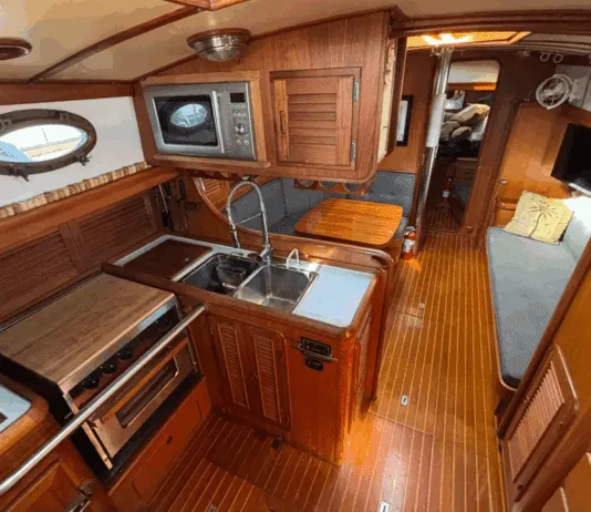 The Union 36's U-shaped galley to port features a deep double sink, three-burner stove/oven, and meticulous teak joinery throughout. (Photo courtesy of YachtWorld.com)
