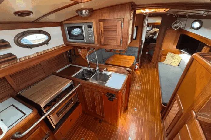 The Union 36's U-shaped galley to port features a deep double sink, three-burner stove/oven, and meticulous teak joinery throughout. (Photo courtesy of YachtWorld.com)