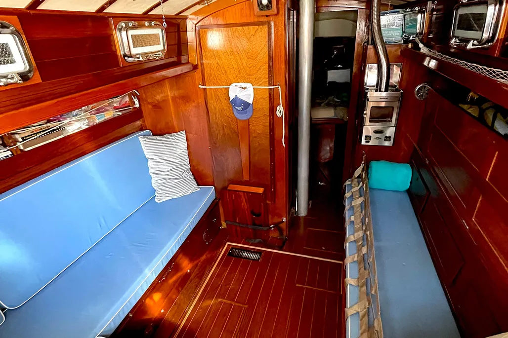 The interior layout is traditional and functional rather than spacious. The Mark II update (post-1971) introduced a molded fiberglass liner and slightly larger portlights, but the narrow beam means the salon remains intimate. Sea berths are excellent, particularly the quarterberth and the settee with a lee cloth. Photo courtesy of YachtWorld.com