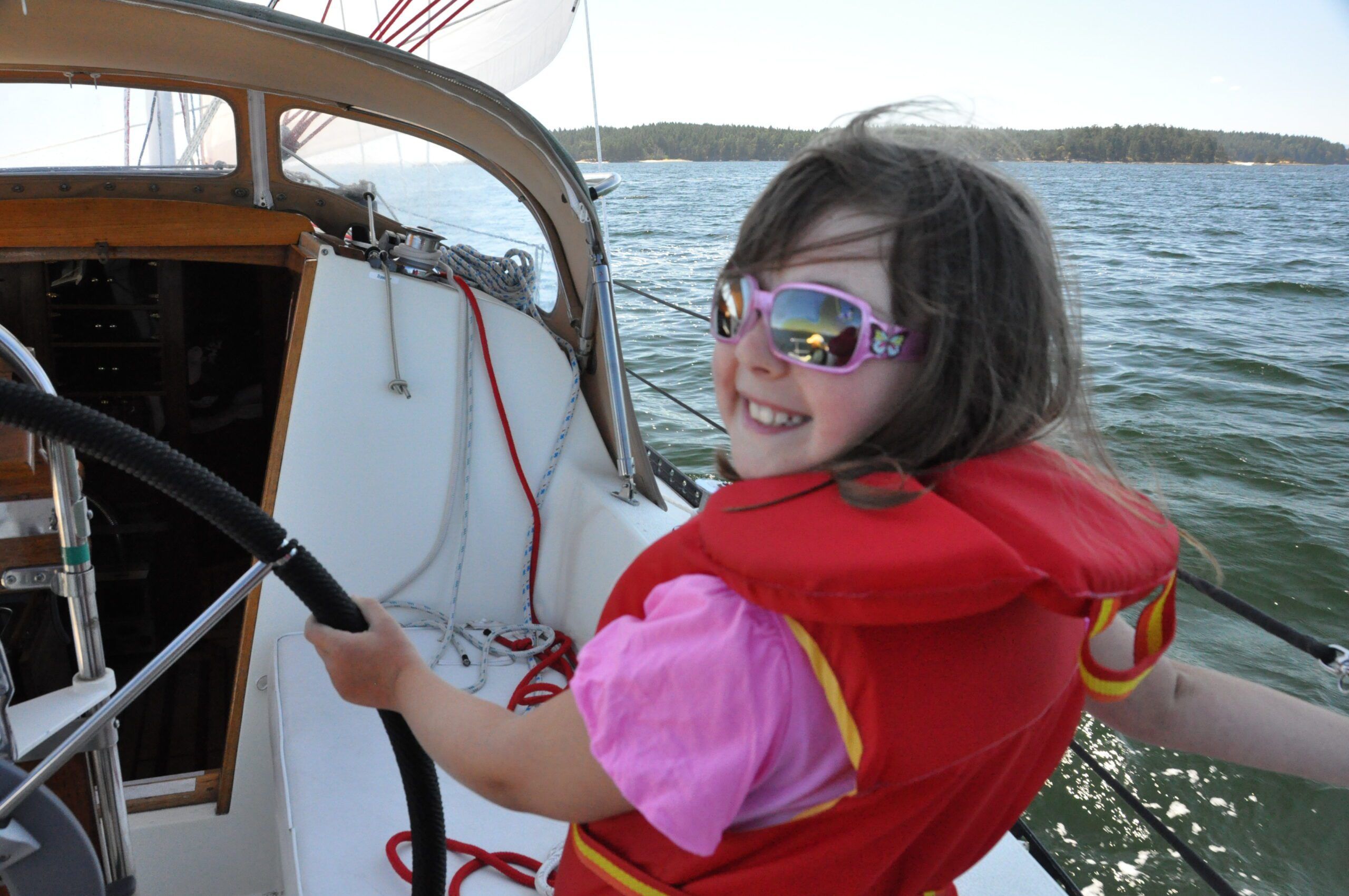 Natasha, age 8, with the sailing bug. Matching your shades to your shirt keeps that life jacket stylish.