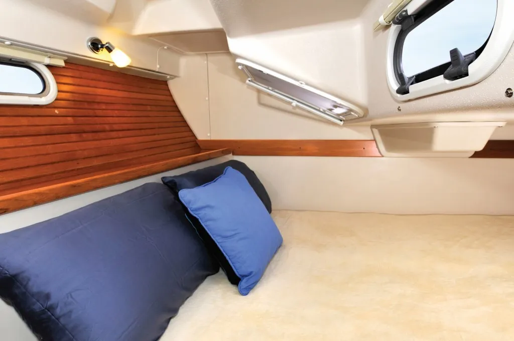 The athwartships double berth in the aft cabin trades standing headroom for a genuinely adult-sized bunk. Opening ports and fixed lights help the space feel less like a cave. (Photo courtesy of Yacht World)
