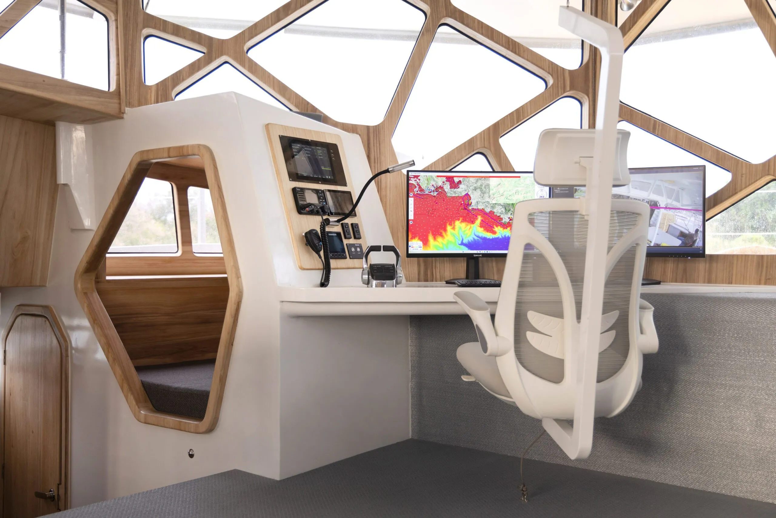 The navigation chair hangs from overhead like a sculpture, positioned at a brilliantly lit station with all-encompassing windows. 