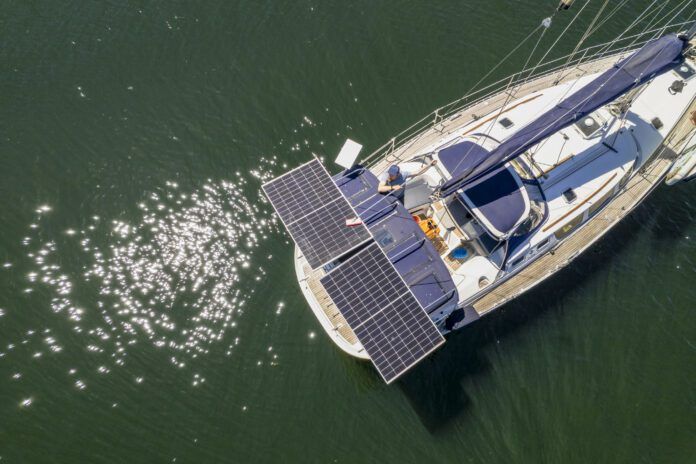 Aerial view of man cleaning solar panels on sailboat