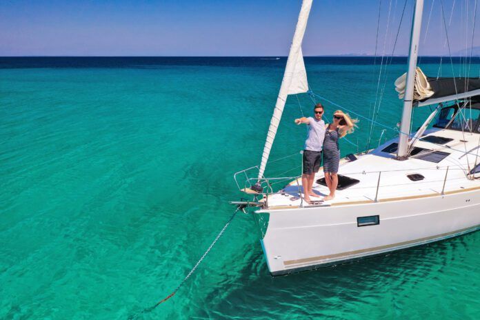 Couple on anchored sailboat, view from drone
